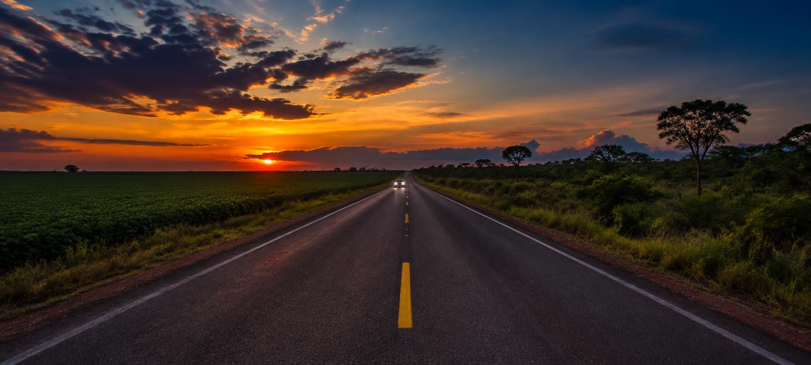 Rodovia de Mato Grosso ao entardecer com ônibus em movimento